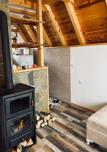 a living room with a fireplace and a stove at Cottage Angel in Žabljak
