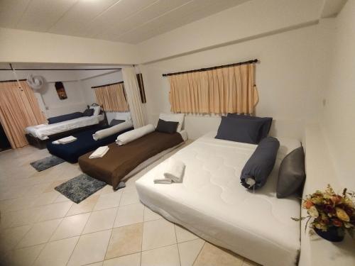 a living room with a large bed and a couch at ม่วนโฮม muan home café&stay in Ban Don