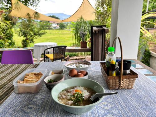 a table with a bowl of soup and some bread at ม่วนโฮม muan home café&stay in Ban Don