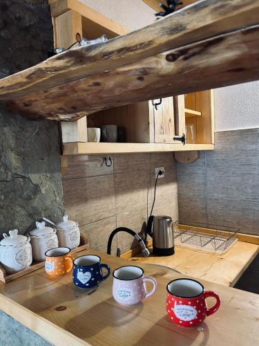 a wooden table with mugs on it in a kitchen at Cottage Angel in Žabljak