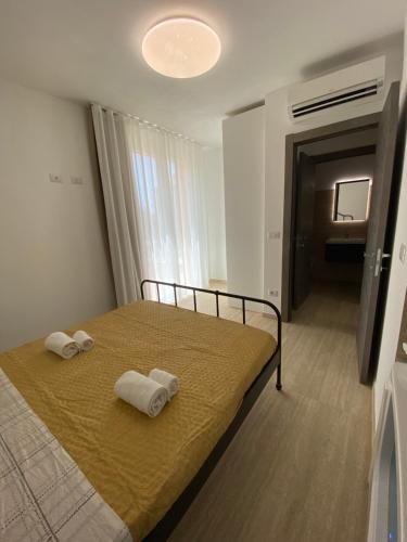 アルゲーロにあるMaris Suite - Appartamento con vasca idromassaggioのベッドルーム1室(ベッド1台、タオル2枚付)