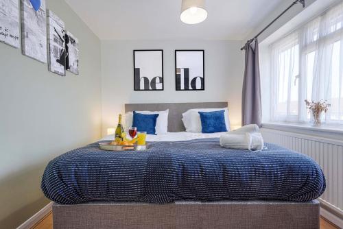 1 dormitorio con 1 cama con manta azul en 5 Bedroom Detached House - Close to City Centre - Sleeps up to 10 guests with Free Parking, Fast Wifi, SmartTVs and Large Garden by Yoko Property, en Milton Keynes