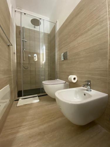 a bathroom with a sink and a toilet and a shower at Maris Suite - Appartamento con vasca idromassaggio in Alghero