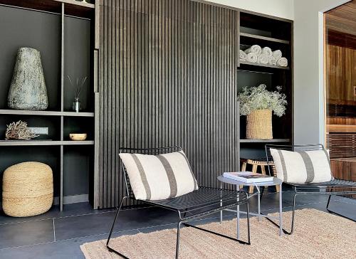 two chairs and a table in a room at Villa The Lake in Mindūnai