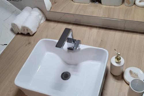 lavabo blanco en el baño con espejo en Appartement COSY proche de Paris en Chambourcy