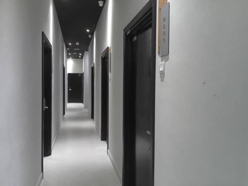 a row of black doors in a hallway at TT99 COZY STAY in Miri