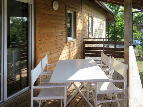 - une table et des chaises sur la terrasse couverte d'une cabine dans l'établissement Apartment Les Cottages du Lac T3 Premium by Interhome, à Parentis-en-Born