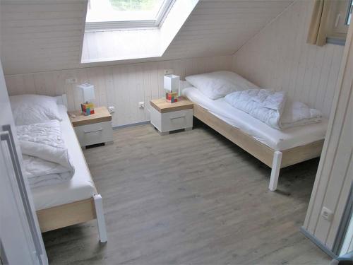a attic bedroom with two beds and a window at Holiday Home Schwan by Interhome in Granzow