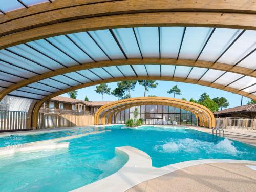 - une vue sur la piscine avec un plafond en bois dans l'établissement Holiday Home Les Cottages du Lac M3 Premium by Interhome, à Parentis-en-Born