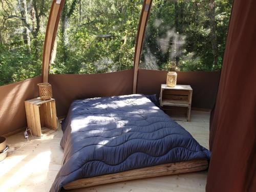 Monoblet的住宿－Camping de Graniers，一张位于带大窗户的房间内的床铺