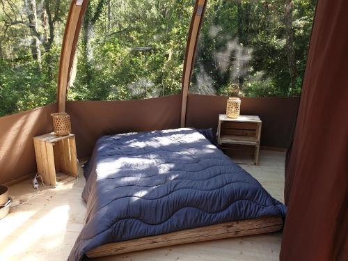 a bed in a room with a large window at Camping de Graniers in Monoblet