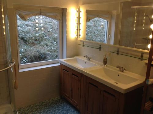 a bathroom with two sinks and a large window at Charmantes Landhaus mit Garten und traumhaftem Fernblick in Thal