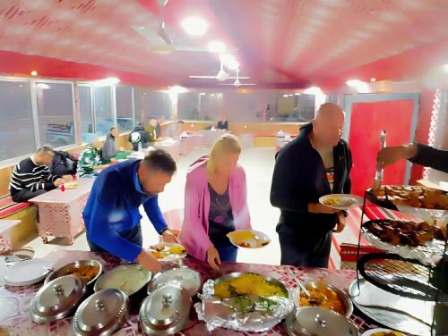 a group of people standing around a table with food at Yellow Star Camp Wadi Rum in Wadi Rum