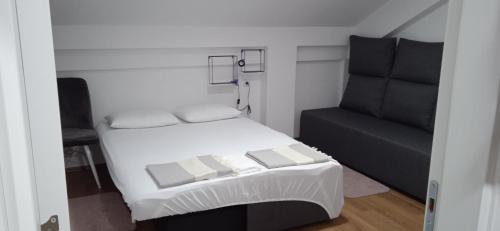 ein kleines Schlafzimmer mit einem Bett und einem Sofa in der Unterkunft Apartment, sweet home in the town-center. in Bitola