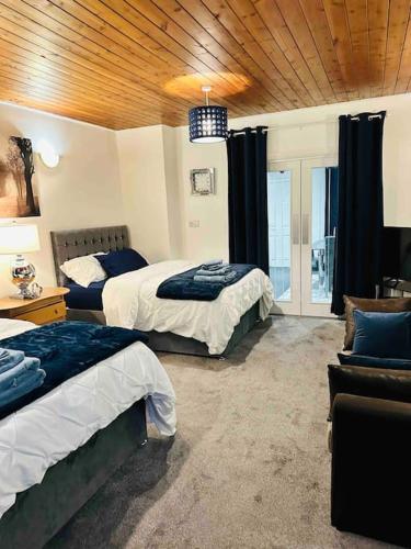 a hotel room with two beds and a couch at Modern 2 Bedroom Apt Derby City in Derby