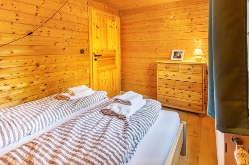 a bedroom with a bed in a wooden cabin at Sommerberg in Unterkirnach