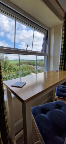 una scrivania in una stanza con una grande finestra di Sycamore Farm a Launceston