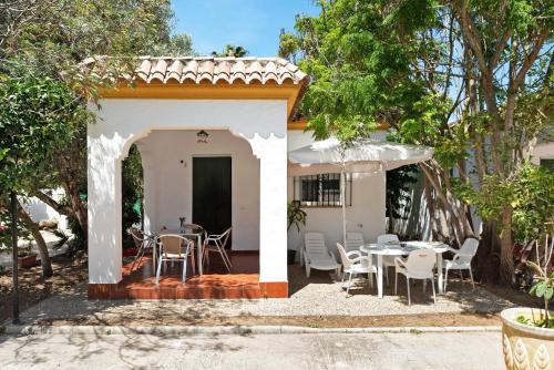 a patio with a table and chairs and trees at Casa Paqui 2 in Roche