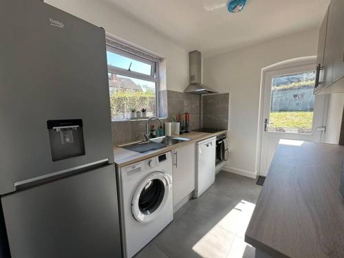 a kitchen with a washer and dryer in it at Spacious 3 Bed House with Parking and Garden in Reading