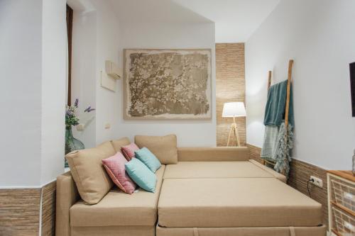 ein Wohnzimmer mit einem Sofa mit Kissen darauf in der Unterkunft Beautiful and cozy- 1Bd 1Bth- Arenal Center in Sevilla