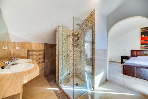 a bathroom with a shower and a sink and a bed at Penthouse Apartment in Elviria in Marbella