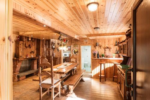Cette chambre en bois dispose d'une table et d'une cheminée. dans l'établissement DOLF - Villa Ombrosa, à Isola