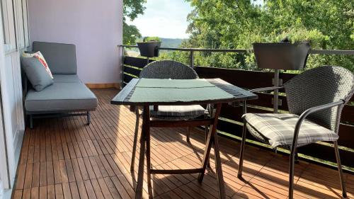 a patio with two chairs and a table on a balcony at Ferienwohnung Asal in Waldbronn