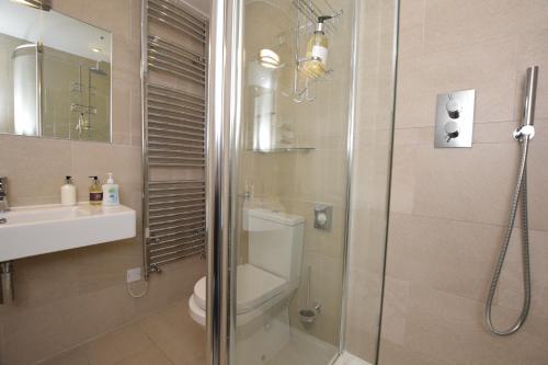 a bathroom with a shower and a toilet and a sink at The Grasmere Hotel in Grasmere
