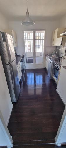 - une grande cuisine avec parquet et appareils en acier inoxydable dans l'établissement Appartement 4 couchages Marseille 13010 proche vélodrome, à Marseille