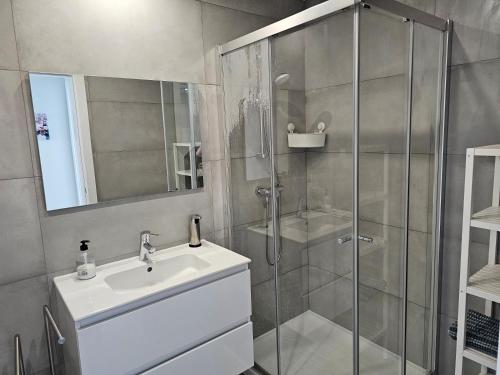 a bathroom with a glass shower and a sink at Apartment Dona Vitória - Monte Gordo Beach in Monte Gordo