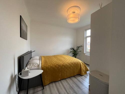 a bedroom with a bed with a yellow blanket at Spacious Modern Flat in Mitcham in Mitcham