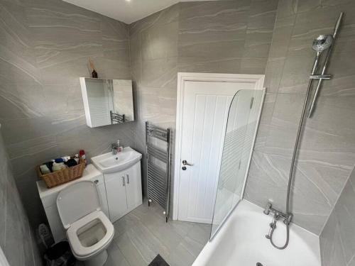 a bathroom with a toilet and a sink and a shower at Spacious Modern Flat in Mitcham in Mitcham