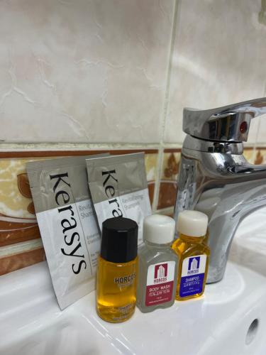a sink with two bottles of essential oils and a faucet at Khujand comfort in Khujand