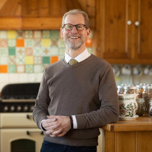 Un hombre de pie en una cocina con los brazos cruzados. en Britannia House, en Lymington