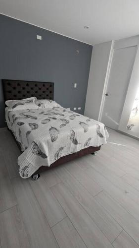 een slaapkamer met een bed met een deken erop bij Espacioso departamento en cayma in Cayma