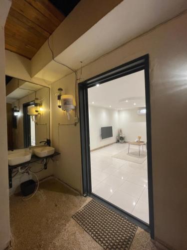 a bathroom with a door open to a room with a sink at شقة فاخرة بقفل ذكي - Luxury apartment in Riyadh