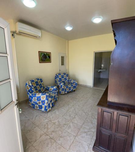 uma sala de estar com duas cadeiras e um sofá em Apartamento Río y Selva em Puerto Iguazú