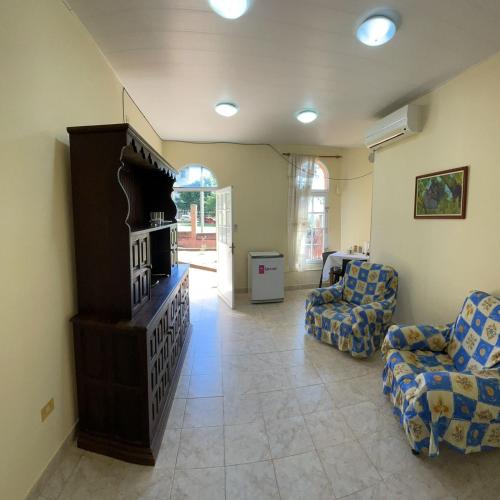 uma sala de estar com duas cadeiras e uma televisão em Apartamento Río y Selva em Puerto Iguazú