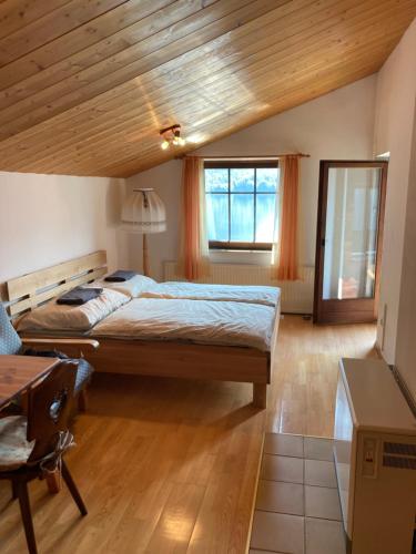 - une chambre avec un grand lit et un plafond en bois dans l'établissement Privatzimmer am See, à Hallstatt