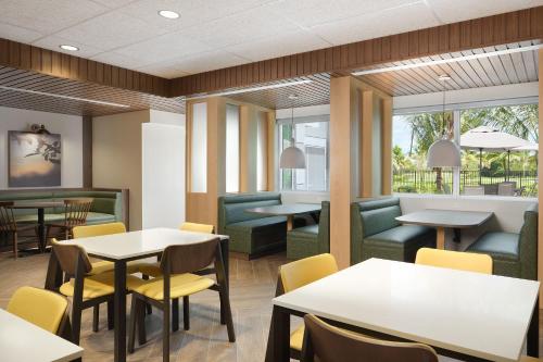 a restaurant with tables and chairs and windows at Fairfield Inn & Suites by Marriott Fort Lauderdale Northwest in Tamarac
