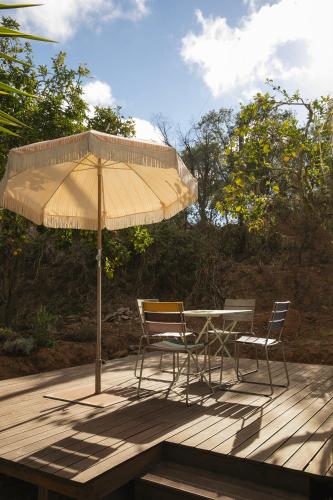 a table and chairs under an umbrella on a deck at Três Figos in São Luis