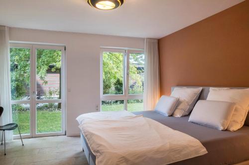 una camera con un grande letto e due finestre di Ferienwohnung Tödiblick a Wangen im Allgäu