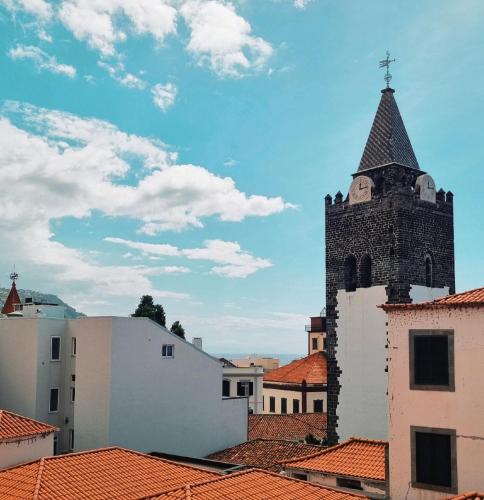 a building with a tower with a steeple on top of roofs at Art House Funchalet in Funchal