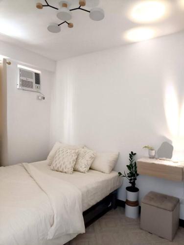 a white bedroom with a bed and a ceiling fan at AR04 H&Bs BrandNew1BR Smart Unit w Alexa in Davao City