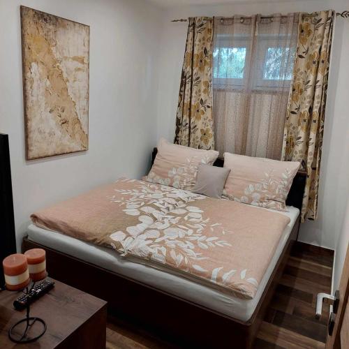 a small bedroom with a bed with a window at Dr Becsey Luxury Apartman in Békéscsaba