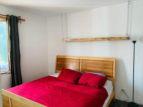 Schlafzimmer mit einem Bett mit roter Bettwäsche und einem Fenster in der Unterkunft 6 people, big, 2 free parkings, near Old Quebec, near river in Québec