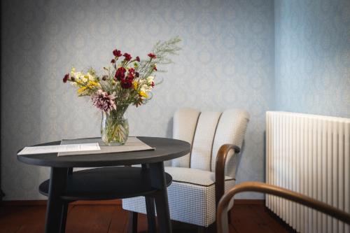 a vase of flowers on a table with two chairs at Just Jimramov in Jimramov