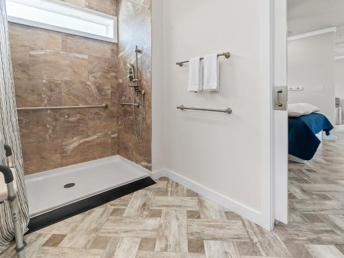 uma casa de banho com uma cabina de duche ao nível do chão e uma cabina de duche ao nível do chão em Shore Point Cottages em Ocean City
