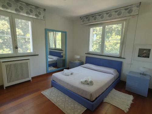 sypialnia z niebieskim łóżkiem i 2 ręcznikami w obiekcie Villino Sabbia d'Oro w mieście San Vincenzo