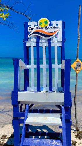a blue chair sitting on the beach next to the water at La Isla Bonita in Punta Rucia